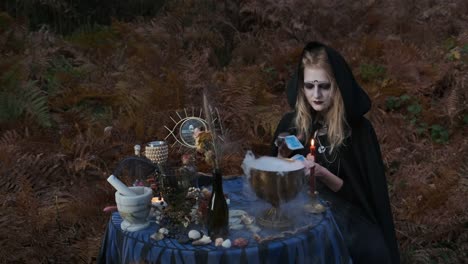 Halloween.-Young-Witch-Spells-At-The-Table.