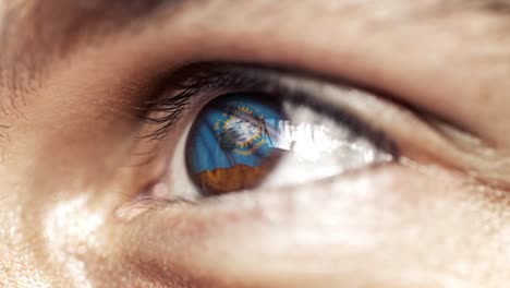Man-with-brown-eye-in-close-up,-the-flag-of-South-Dakota-state-in-iris,-united-states-of-america-with-wind-motion.-video-concept