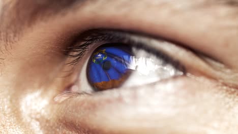 Man-with-brown-eye-in-close-up,-the-flag-of-Nevada-state-in-iris,-united-states-of-america-with-wind-motion.-video-concept