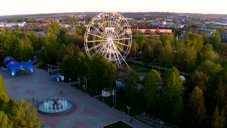 Park-mit-Tracks-und-großem-weißen-Riesenrad-Luftaufnahme