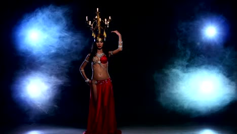 Attractive-belly-dancer-go-on-dancing-with-candles,-her-head,-black,-smoke