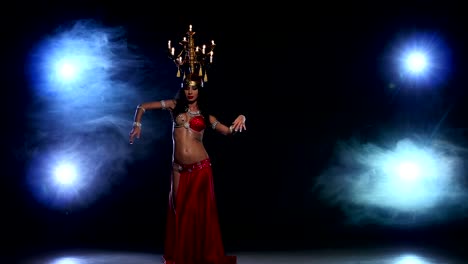 Attractive-belly-dancer-girl-starts-dancing-with-candles-on-her-head,-black,-smoke