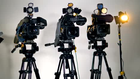 A-row-of-several-professional-cameras-on-tripods.