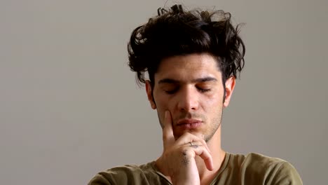 Thougtful-young-man-opens-his-eyes-and-looking-camera--indoor