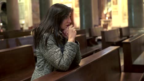 religious-girl-praying,-kneeling-in-church