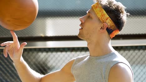 White-handsome-man-spinning-basket-ball-on-finger,-summer-activities,-balance