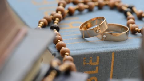 Dos-anillos-de-boda-con-cros-en-el-bookshelh,-zoom,-disparo-con-slider