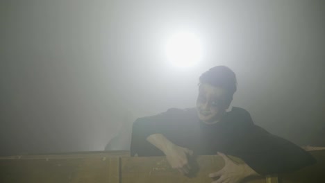 Paar-der-jungen-Zombies-erschreckende-Kleidung-aufwachen-am-Tag-der-Toten-und-raus-aus-ihren-Särgen-in-Nebel