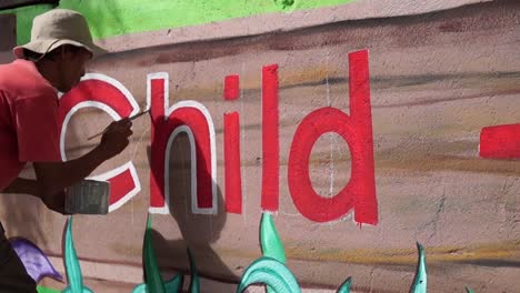 Mural-painter-draws-a-letter-h-on-school-wall.-time-lapse