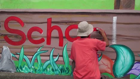 Mural-painter-draws-a-letter-o-on-school-wall.-time-lapse