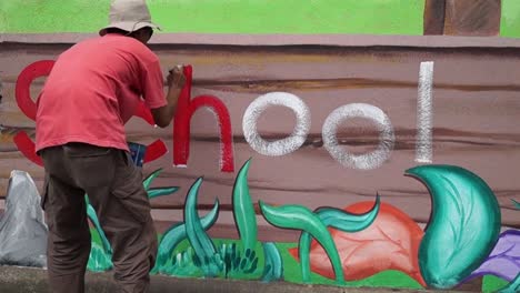 Mural-painter-draws-a-letter-h-on-school-wall.-time-lapse