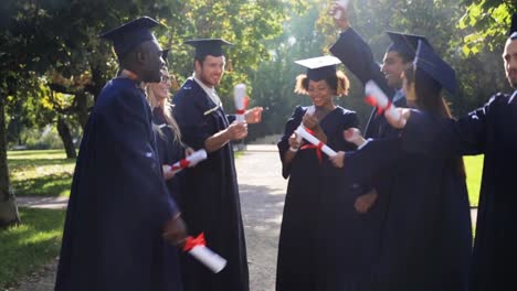 happy-students-in-mortar-boards-with-diplomas