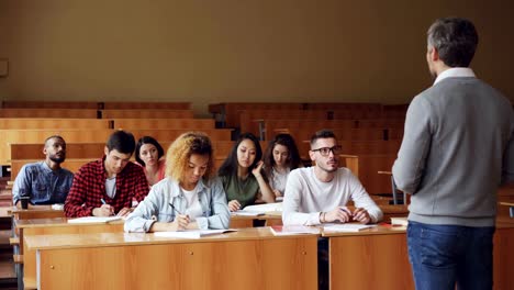 Tutor-emocional-está-hablando-a-los-estudiantes-explicar-información-nuevos-alumnos-atentos-escuchando-y-tomando-notas.-Concepto-de-profesión-y-Educación-de-las-personas.