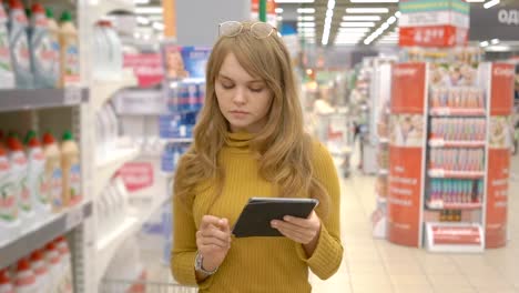 Mujer-cliente-utilizando-una-tableta-digital-en-el-supermercado