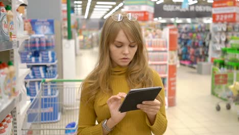 Mujer-cliente-utilizando-una-tableta-digital-en-el-supermercado