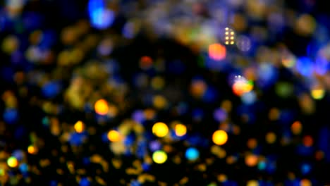 Defokussierten-schillernden-bunten-Glitter-Konfetti,-schwarzer-Hintergrund.-Urlaub-abstrakte-festliche-Bokeh-Lichtpunkte.