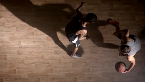 Topview,-two-basketball-players-playing-one-on-one-indoors