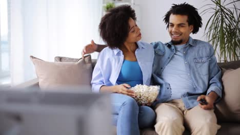 smiling-couple-with-popcorn-watching-tv-at-home