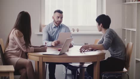 Jefe-mujer-hermosa-escuchando-joven-Japon-en-entrevista-de-trabajo-en-la-oficina-moderna,-uniones-de-empleado-caucásico-en