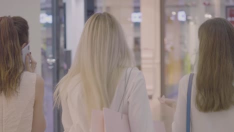 Back-view-of-young-women-walking-in-shopping-mall