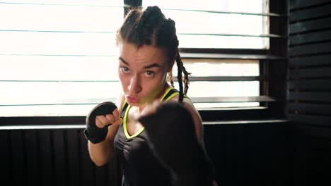 mujer-joven-hermosa-mueve-boxeo-entrenamiento-en-gimnasio-de-perforación