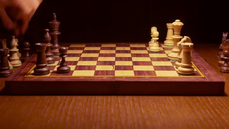 chess-player-making-a-move-in-the-game-on-wooden-table