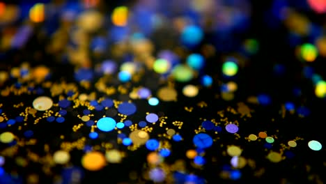 Defocused-shimmering-multicolored-glitter-confetti,-black-background.-Party,-magic,-imagination.-Rainbow-colors,-sparkle-circles.-Holiday-abstract-festive-texture-of-shiny-blurred-bokeh-light-spots.