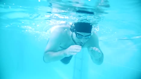 Behinderte-Mensch-schwimmt-in-Richtung-der-Kamera-in-einem-Schwimmbad.-Unterwasser-Schuss