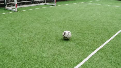 A-soccer-ball-on-an-artificial-lawn-in-front-of-the-goalpost