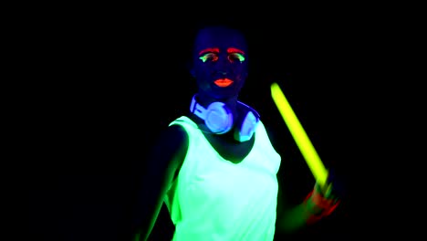 Woman-with-UV-paint,-glowing-bracelet,-clothing-,-headphones,-using-chemical-stick.-Caucasian-woman.-Women.