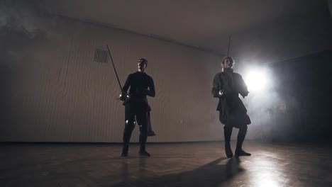 Medieval-warriors-training-with-swords-indoors-in-slow-motion