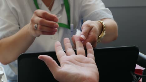 Footage-of-a-nurse-taking-blood-from-a-persons-finger-in-order-to-determine-his-blood-type