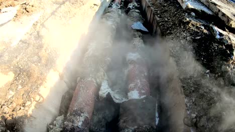 Damaged-district-heating-pipeline-in-street-trench-with-hot-water-leaking