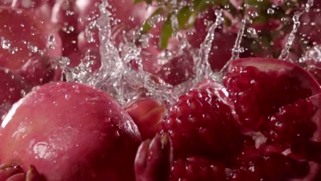 Fallen-im-Wasser-mit-Spritzen-zwischen-Granatapfel-Granatapfel.-Slow-motion