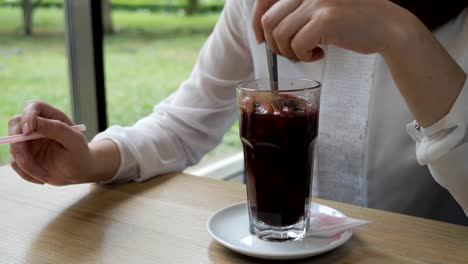 Mujer-joven-en-un-café-mueve-vino-caliente