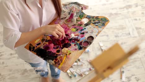 A-young--girl-in-a-white-shirt-draws-on-canvas-in-the-studio.-Art.