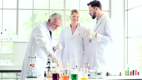 Science-teacher-and-students-team-working-with-chemicals-in-lab