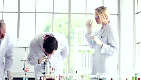 Science-teacher-and-students-team-working-with-chemicals-in-lab