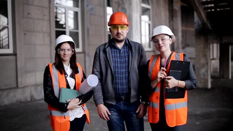 Engineer-Men-and-two-women-inspector-Group-Team-Looking-Camera-Under-Construction-Building-Architecture.