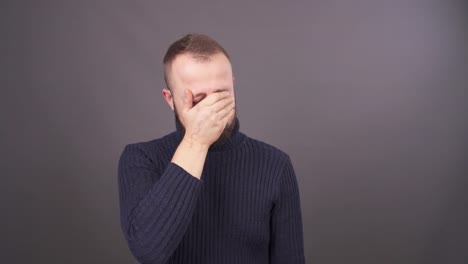 Portrait-of-a-young-crying-man.-Isolated-on-grey-background.