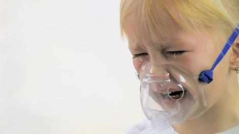 Four-year-old-girl-doing-breathing-procedures-through-an-inhaler-mask-in-a-hospital-in-slow-motion.