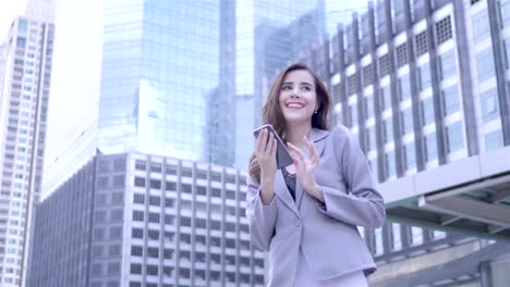 Young-caucasian-businesswoman-Using-Smart-Phone-are-walking-in-city-centre-Thailand.--communication,-everyday-life-Technology-Concept.-SLOW-MOTION