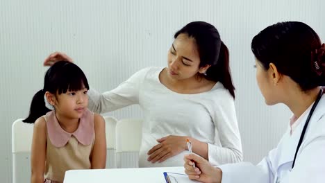 Little-girl-and-mom-talking-to-doctor-at-clinic.-Doctor-explain-to-woman-and-her-daughter-about-problem.-People-with-Healthcare-and-Medical-Concept.