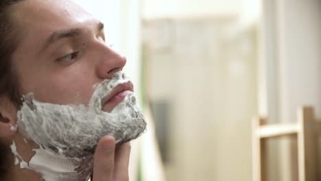 Higiene-de-los-hombres.-Aplicación-de-espuma-de-afeitar-en-Closeup-barba-hombre