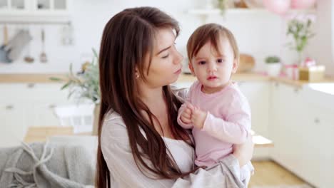 Patient-young-mother-comforting-her-lovely-baby-daughter-crying-in-her-arms