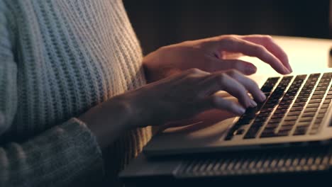 Hands-of-woman-working-on-laptop-in-dark-room.-Close-up