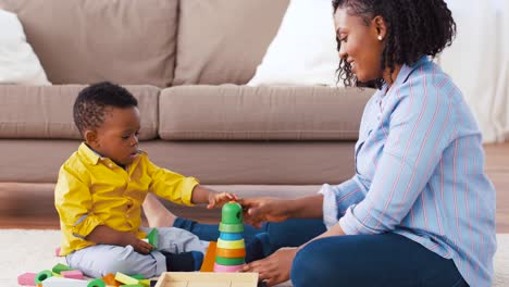 madre-y-el-bebé-jugando-con-bloques-de-juguete-en-casa