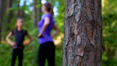 Mom-and-daughter-doing-gymnastics-in-the-forest.