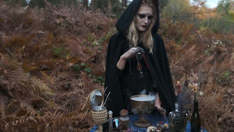 Halloween.-Young-Witch-Spells-At-The-Table.