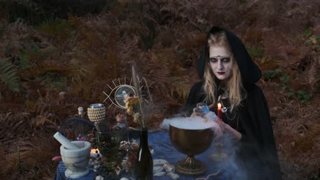 Halloween.-Young-Witch-Spells-At-The-Table.